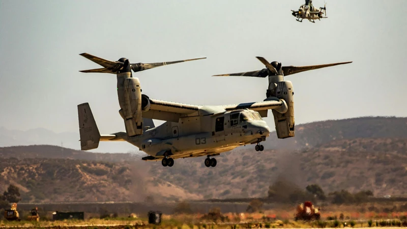 A military helicopter taking off vertically while another hovers in the background.